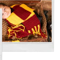 "The chosen one." A newborn dressed as Harry Potter, complete with a Gryffindor scarf. This is a perfect theme for parents who are fans of the wizarding world.