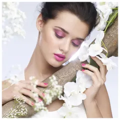 A soft and romantic beauty image featuring floral elements and vibrant pink makeup. The composition creates a dreamy, ethereal mood, perfect for a spring cosmetics collection.