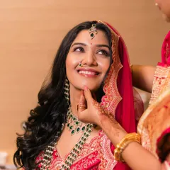 The final touches. A mother gently adjusts her daughter's chin, a simple gesture full of love, as the bride gets ready.