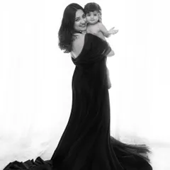The elegance of motherhood captured in a classic black and white fine art portrait. The flowing black gown, part of my client wardrobe, adds a touch of drama and timelessness to this intimate mother and child moment.