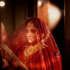 A bride captured in a moment of quiet reflection, her face partially veiled. This moody, intimate style of wedding photography focuses on the internal emotions of the day, not just the external celebration.