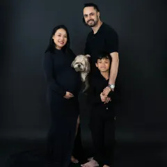Our simple, dark backdrops are perfect for creating dramatic and timeless family portraits. The focus remains entirely on the family's emotions and connections, as seen in this maternity shoot with a big brother and family pet.