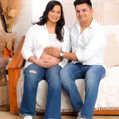 A beautiful, happy portrait of the couple looking directly at the camera, showcasing their shared joy in a comfortable and natural setting.