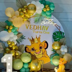 A roaring celebration for Vedhav's first birthday with this adorable Simba theme. The setup featured a crowned Simba on the backdrop, framed by a green, gold, and white balloon arch, a light-up number '1', and a small Simba statue for the perfect jungle vibe.