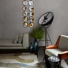 A serene grey living space in the Baid Residence, featuring a minimalist wall piece from Foscarini and a chic light from Pallucco. The space is a study in understated elegance and sophisticated curation.