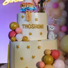 We arranged this lovely two-tier cake for Thoshini's party. The design included a cute doll topper, stars, and decorative spheres that perfectly matched the pastel theme of the event.