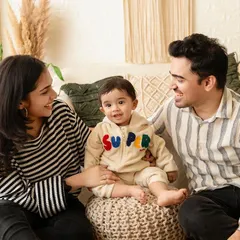 A family celebrating their son's first birthday with a studio photoshoot. Milestone sessions are a perfect way to capture this important moment.