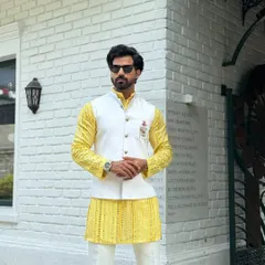 A confident pose in our yellow kurta and white jacket combination. This ensemble is perfect for daytime festivities, offering a bright and cheerful look without compromising on sophistication.