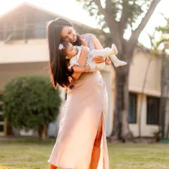 A mother gently holding her baby in the soft afternoon light. This portrait captures the tenderness and serenity of early motherhood in a natural, outdoor setting.
