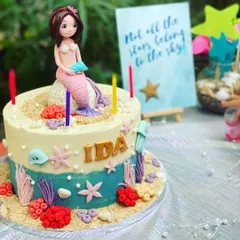 A close-up of the beautiful, custom-made mermaid cake. I work with talented bakers to ensure even the treats match the party's theme perfectly, complete with a mermaid figure, edible sand, and sea creatures.