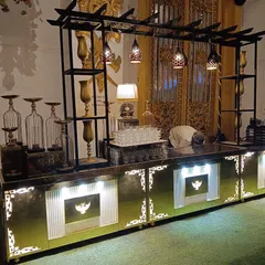 A view of the buffet counter setup before service, highlighting the decorative shelving, hanging lamps, and glassware that are part of our comprehensive presentation.