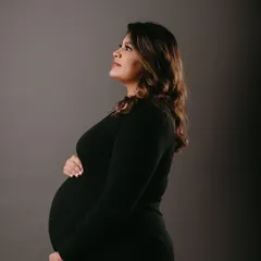 A classic studio portrait for a maternity shoot. The makeup is elegant and timeless, with soft definition on the eyes and a flawless base to create a polished and sophisticated look.