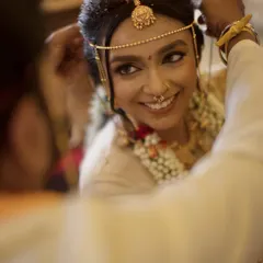 A beautiful moment from a Kannada wedding ceremony. We focus on capturing the bride's joyful expression as the groom adorns her, highlighting the traditional jewelry and the genuine emotion of the ritual.