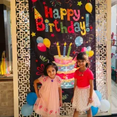Two happy guests posing in front of the birthday banner at Maavi's party. My studio is designed to be a bright, cheerful, and welcoming space for kids to celebrate together.