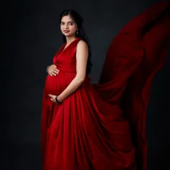 We use fabric tossing techniques to add movement and drama to your photos. This shot captures a bold red gown in motion against a classic dark backdrop.