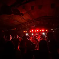 The view from my console as the crowd loses it under the red lights. This is the energy I build, a packed dance floor moving as one.