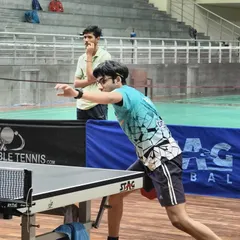 A young player fully focused during a match at the Indian Table Tennis League. Our training prepares athletes for the pressure of competition, teaching them to stay calm and execute their shots.