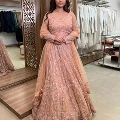 A full-length shot of the peach lehenga, showing its graceful A-line silhouette and the beautiful shimmer of the embroidery.