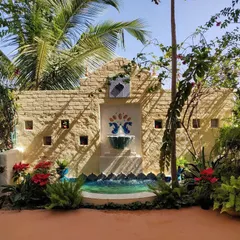 This backyard features a custom-built wall with an integrated water fountain. The combination of stone cladding, mosaic art, and the gentle sound of water creates a peaceful and artistic focal point.