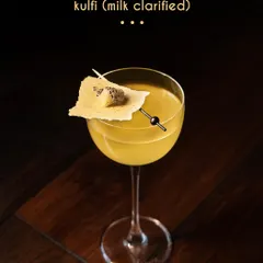 We present our Kulfi cocktail, a nostalgic dessert reimagined as a sophisticated drink. This milk-clarified creation captures the essence of traditional kulfi, blending gin with the aromatic warmth of cardamom, saffron, and almond for a truly unique experience.
