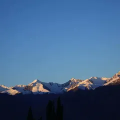 The first light of day hitting the snow-capped peaks of the Himalayas. Catching the sunrise over these mountains is a core part of our Ladakh fitness expedition.