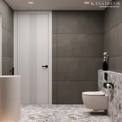 This angle shows how the different elements of the bathroom come together. The terrazzo-style tile on the floor and half-wall provides continuity, while the large grey tiles create a calm backdrop. The clean lines of the pedestal sink and the simple white door maintain the room's modern, uncluttered feel.