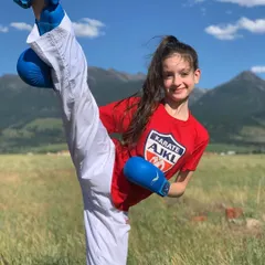 If you can't do it slow, you can't do it fast. A young student shows amazing flexibility and control with a high kick during an outdoor practice. We focus on proper technique from day one.