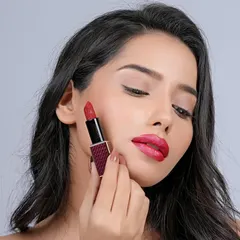 A beauty shot demonstrating the application of a red lipstick. This type of image is highly effective for product tutorials and social media marketing.