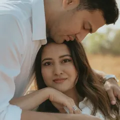 A tender moment where the groom kisses the bride's forehead as she looks calmly at the camera. This intimate portrait, bathed in soft natural light, is a perfect example of capturing raw emotion.