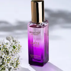 This photo for Bella Vita Luxury perfume uses dappled light and delicate flowers to suggest the fragrance's scent profile. The lighting highlights the bottle's gradient color and elegant shape.