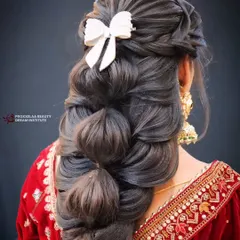 This isn't your average braid. I've created a voluminous bubble braid, adding texture and finishing it with a stylish white bow for a look that's both playful and elegant, ideal for a sangeet or reception.