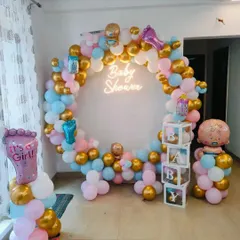 This vibrant baby shower decoration features a full circular balloon arch in pink, blue, white, and gold. The design is centered around a "Baby Shower" neon sign and includes transparent "BABY" blocks and character foil balloons, creating a complete and festive photo corner.