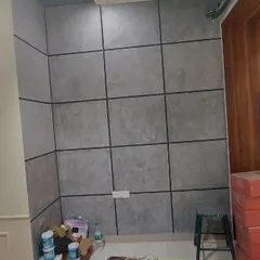 A corner view of a room with a concrete panel effect wall finish, demonstrating how the texture wraps around the space for a cohesive industrial look.