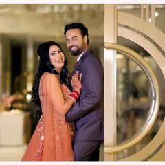 A joyful and classic couple portrait from their reception. Their happy smiles and comfortable embrace in front of an elegant doorway make for a perfect, timeless memory.