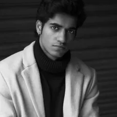 A striking black and white close-up portrait. The clean background and focused lighting draw all attention to the model's intense expression and features.