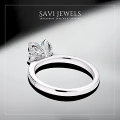 A solitaire diamond ring is an eternal expression of love. This particular design features a brilliant round solitaire held in a unique, petal-like setting that is also studded with smaller pavé diamonds. The band itself is also lined with diamonds, ensuring sparkle from every angle.