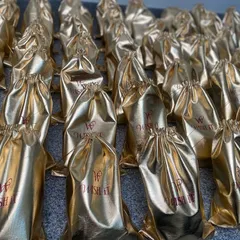 A frame full of gold. These custom Wishit potlis, shining and ready, were part of a large order heading to the US for a cultural celebration.