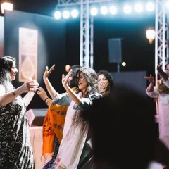 A group of friends dancing together under the bright stage lights of a concert. This photo is all about the shared experience and collective energy of a live performance.