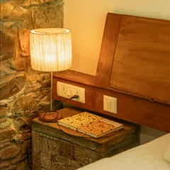 Every corner tells a story. This cozy bedside setup with a rustic chest and warm lamp is perfect for unwinding with a book after a day of exploring.