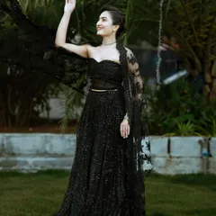The full look of the black sequined lehenga set, complete with a delicate lace cape for added drama.