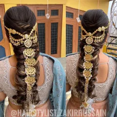 This is an example of a highly detailed and traditional bridal braid. I incorporated an elaborate gold 'jada' hair accessory that cascades down the length of the braid, creating a truly regal and unforgettable look for the wedding day.