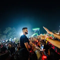AP Dhillon surrounded by his fans, reaching out to connect with the massive crowd. I design my stage setups to allow for these powerful, intimate interactions.