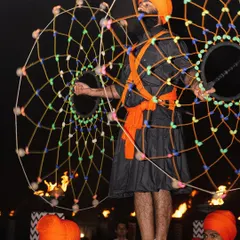 A captivating performance during the Jaago night. A Sikh performer showcases a traditional art form with a large, illuminated prop, adding a spectacular visual element to the birthday festivities.