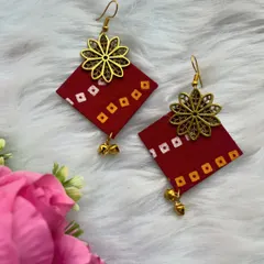 A personal touch for your outfit. This pair of red bandhani print fabric earrings is adorned with a gold-tone floral charm and tiny ghungroos. They are completely handmade and perfect for casual wear.