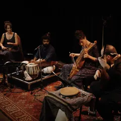 A moment from our 'Sangam, Confluences' performance. This image showcases the heart of our musical fusion, with artists playing the Indian Tabla and the Swedish Nyckelharpa side-by-side in an intimate, dramatic setting.