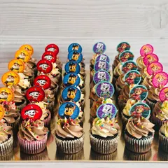 This large order of Paw Patrol themed cupcakes is perfect for a big birthday bash. I've arranged the cupcakes by character, including Chase, Marshall, and Skye, each with a custom paper topper and colorful sprinkles on a swirl of ombré buttercream.