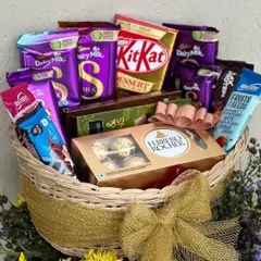 The ultimate chocolate lover's basket, perfect for anniversaries or celebrations. This hamper is overflowing with a variety of Dairy Milk chocolates, KitKat, and a box of Ferrero Rocher.