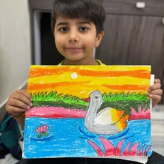 A first-grade student shows off his beautiful drawing of a duck swimming in a pond at sunset. In my drawing classes for kids, we focus on basic shapes and colour blending to create charming animal art.