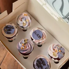 A closer look at the elegant purple and pink bridal shower cupcakes. You can see the custom fondant plaques with the date and hashtag for the couple.