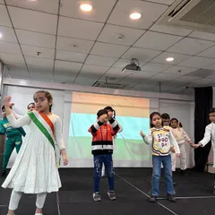 Students perform a patriotic dance on stage to celebrate Republic Day, expressing their love for the nation through coordinated movements.